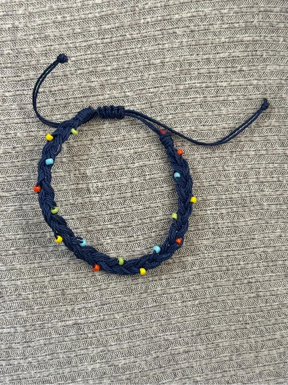 Dark blue adjustable bracelet w yellow, red, blue & green beads throughout